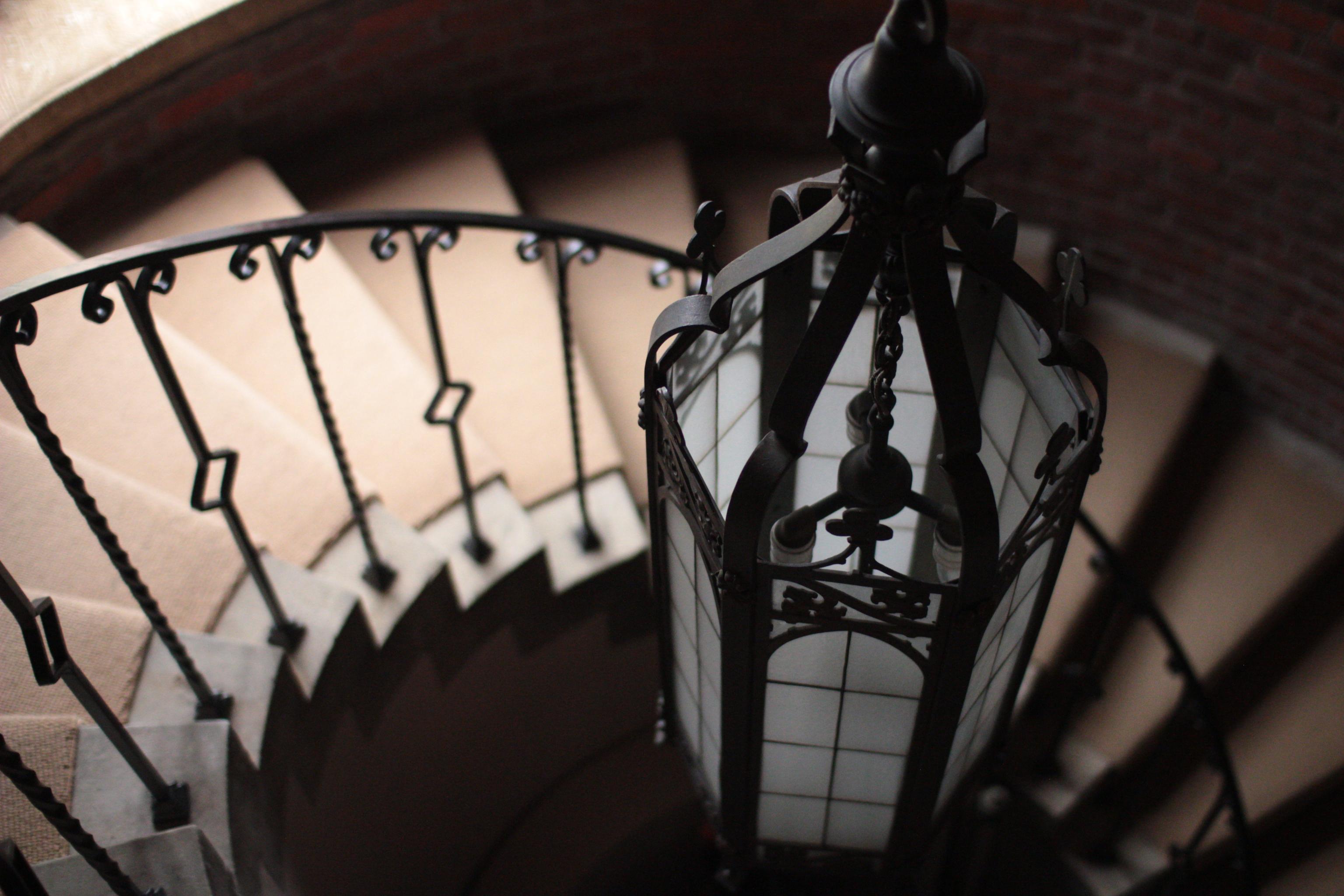 photo of a lamp suspended over a spiral staircase